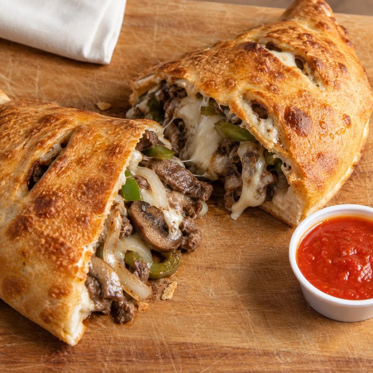 Philly steak, melted cheese, mushrooms, green peppers, and onions baked inside a golden calzone.